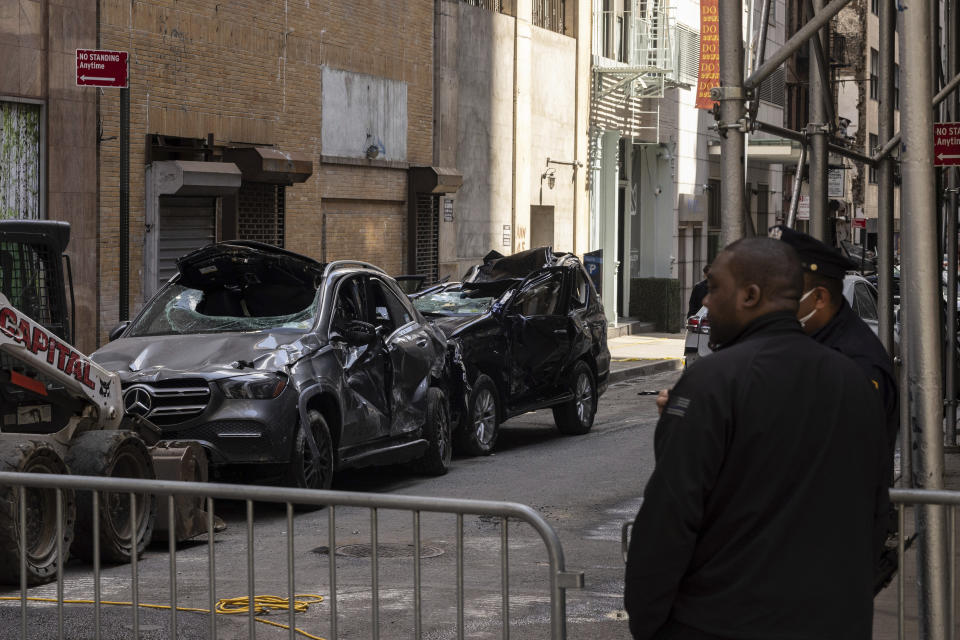 Cars are parked outside a partially collapsed parking garage in the Financial District of New York, Wednesday, April 19, 2023, in New York. The parking garage collapsed Tuesday, killing one worker, injuring five and crushing cars as concrete floors fell on top of each other like a stack of pancakes, officials said. (AP Photo/Yuki Iwamura)