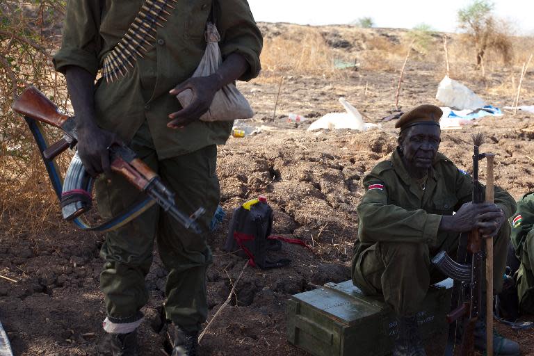 Sudan People's Liberation Army (SPLA) soldiers take a rest outside the United Nations Mission in South Sudan (UNMISS) base in Malakal on March 20, 2014