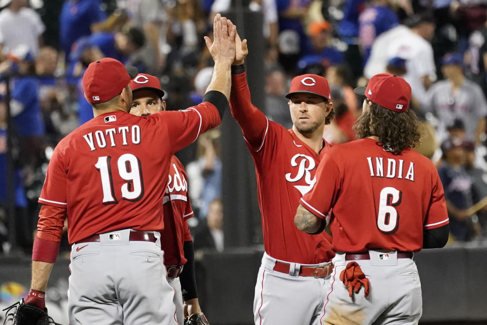 Cincinnati Reds' Joey Votto (19), Eugenio Suarez, second from left, Kyle Farmer, second from right, and Jonathan India (6) celebrate after defeating the New York Mets in a baseball game, Friday, July 30, 2021, in New York. (AP Photo/Mary Altaffer)