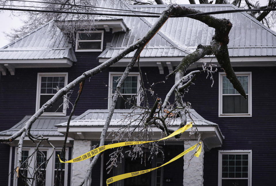 A fallen limb rests awkwardly on a power line on Thursday, Feb. 3, 2022 in Memphis, Tenn. A major winter storm that already cut electric power to about 350,000 homes and businesses from Texas to the Ohio Valley was set to leave Pennsylvania and New England glazed in ice and smothered in snow.(Patrick Lantrip/Daily Memphian via AP)