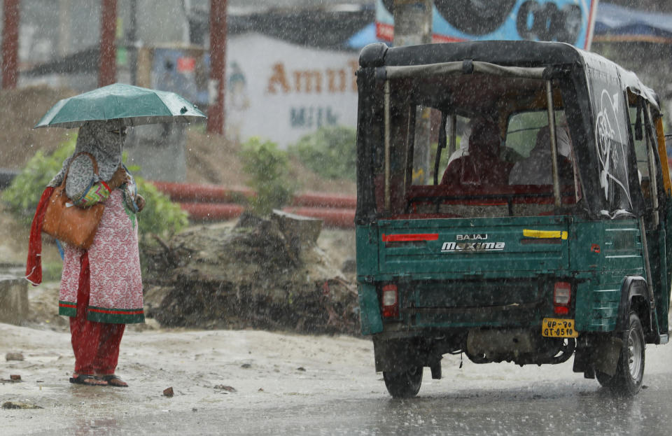 A woman with her face covered stands in the rain in Prayagraj, India, Wednesday, July 29, 2020. India is the third hardest-hit country by the pandemic in the world after the United States and Brazil. (AP Photo/Rajesh Kumar Singh)