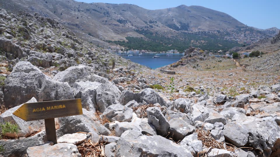 A direction sign on a rocky path in the hills of Pedi, a small fishing village in Symi, pointing toward Agia Marina, where the body of TV doctor and columnist Michael Mosley was discovered. - Yui Mok/PA