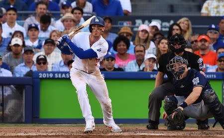 Oct 17, 2018; Los Angeles, CA, USA; Los Angeles Dodgers center fielder Cody Bellinger (35) hits a single to load the bases in the seventh inning against the Milwaukee Brewers in game five of the 2018 NLCS playoff baseball series at Dodger Stadium. Mandatory Credit: Robert Hanashiro-USA TODAY Sports