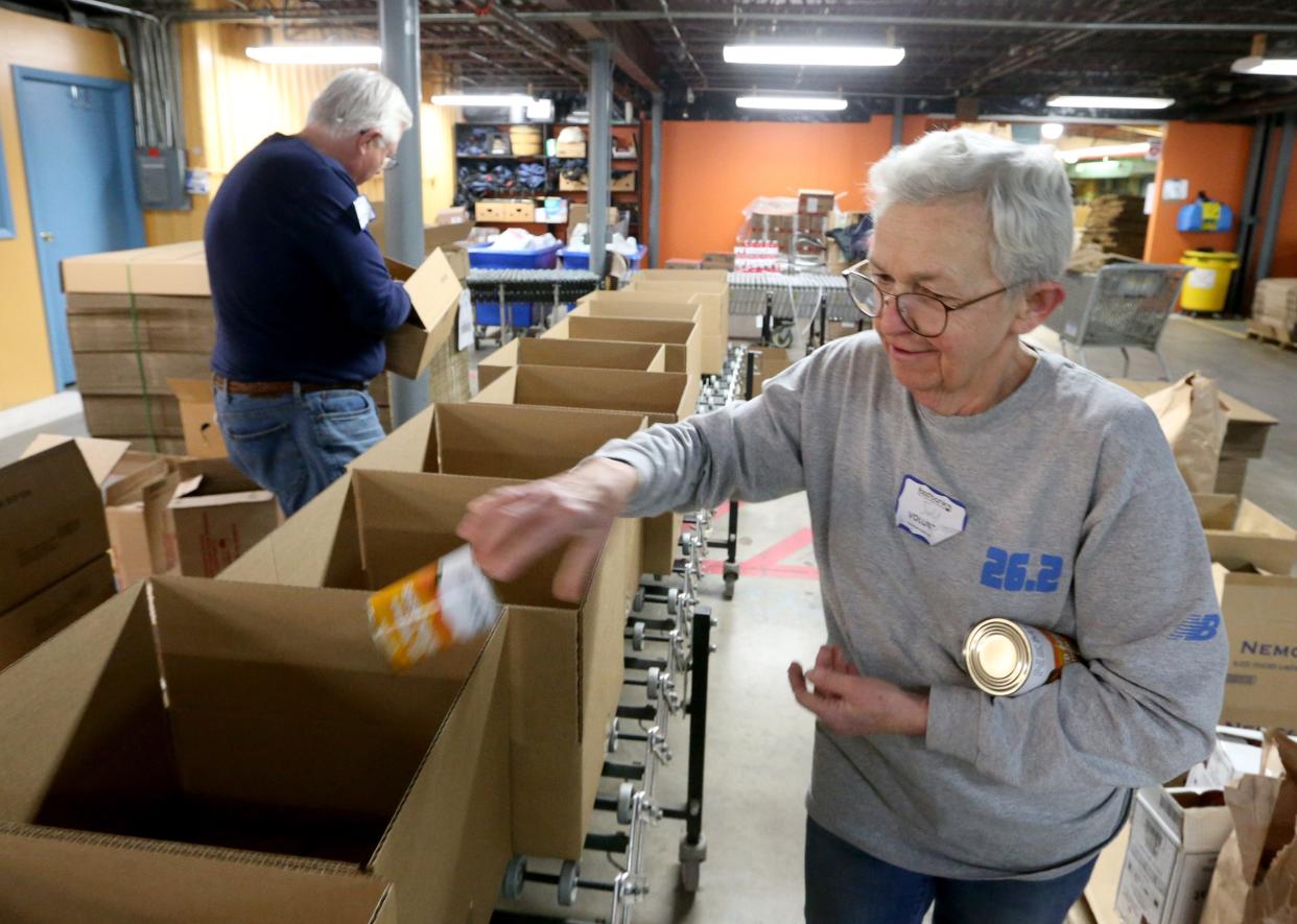 Volunteers Curt Phillips, left, and Judy Phillips create and pack food boxes for the Goshen area Tuesday, Jan. 31, 2023, at the Food Bank of Northern Indiana in South Bend.