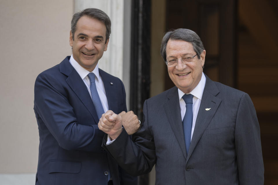 Greek Prime Minister Kyriakos Mitsotakis, left, welcomes Cypriot President Nicos Anastasiades during their meeting in Athens, on Tuesday, July 14, 2020. (AP Photo/Petros Giannakouris)