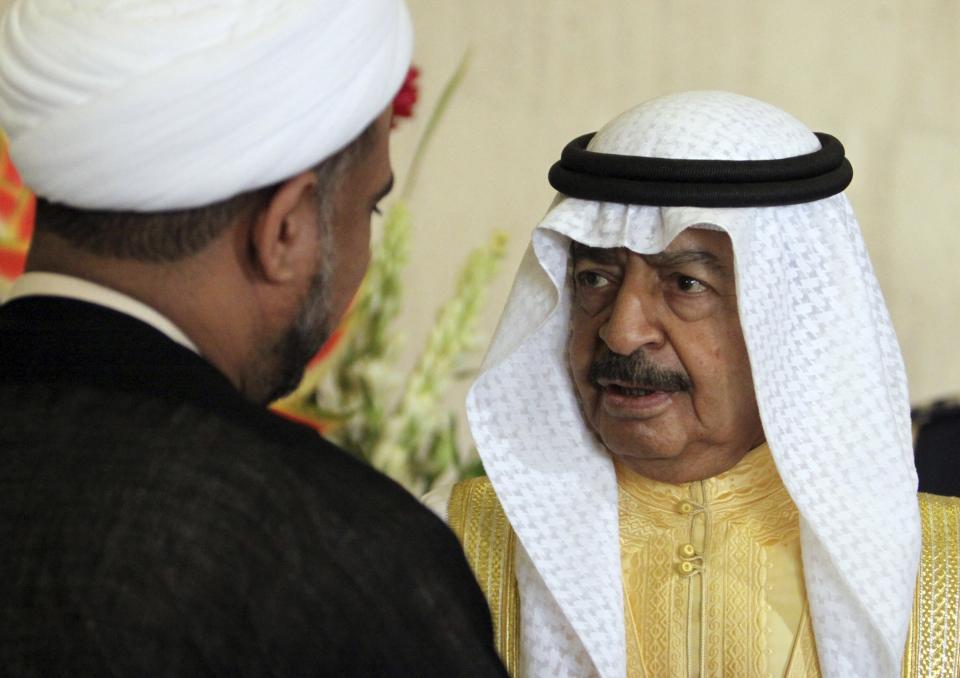 FILE - In this Dec. 21, 2010, file photo, Bahraini Prime Minister Khalifa bin Salman Al Khalifa speaks with opposition parliament member Sheik Hassan Sultan after the opening session of the new parliament in Manama, Bahrain. Prince Khalifa, one of the world’s longest-serving prime ministers who led his island nation’s government for decades and survived the 2011 Arab Spring protests that demanded his ouster over corruption allegations, died on Wednesday, Nov. 11, 2020. He was 84. (AP Photo/Hasan Jamali, File)