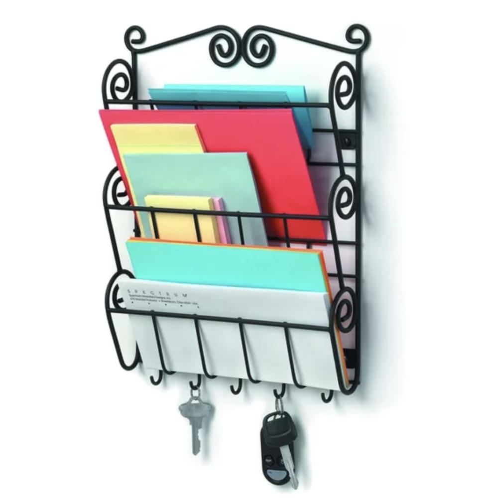 Wall-mounted organizer with slots holding mail and a shelf with key hooks