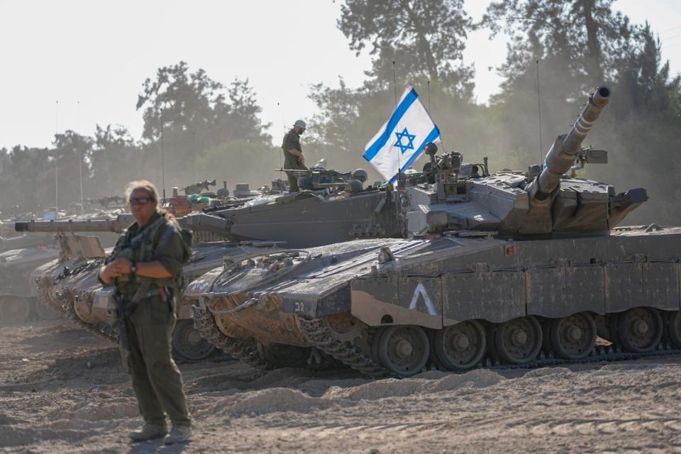 Israeli soldiers work on a tank at a staging area near the border with the Gaza Strip (Copyright 2023 The Associated Press. All rights reserved.)