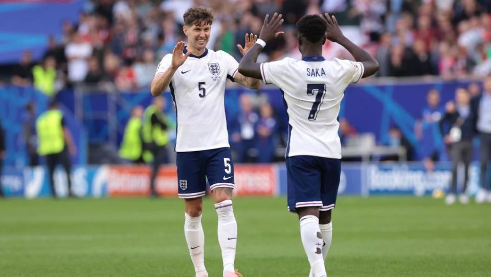 John Stones congratulates and Bukayo Saka