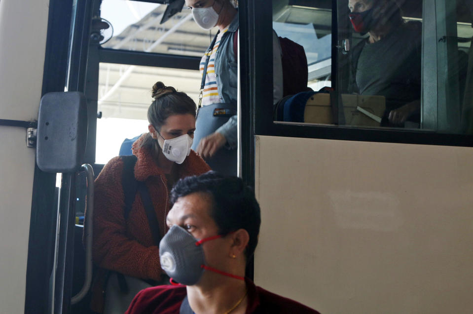 Stranded American citizens arrive to board a Qatar Airways flight at the Tribhuvan International Airport in Kathmandu, Nepal, Tuesday, March 31, 2020. Several American citizens are stranded in Nepal due to the nationwide lockdown enforced in an attempt to stop the coronavirus spread. The new coronavirus causes mild or moderate symptoms for most people, but for some, especially older adults and people with existing health problems, it can cause more severe illness or death. (AP Photo/Niranjan Shrestha)