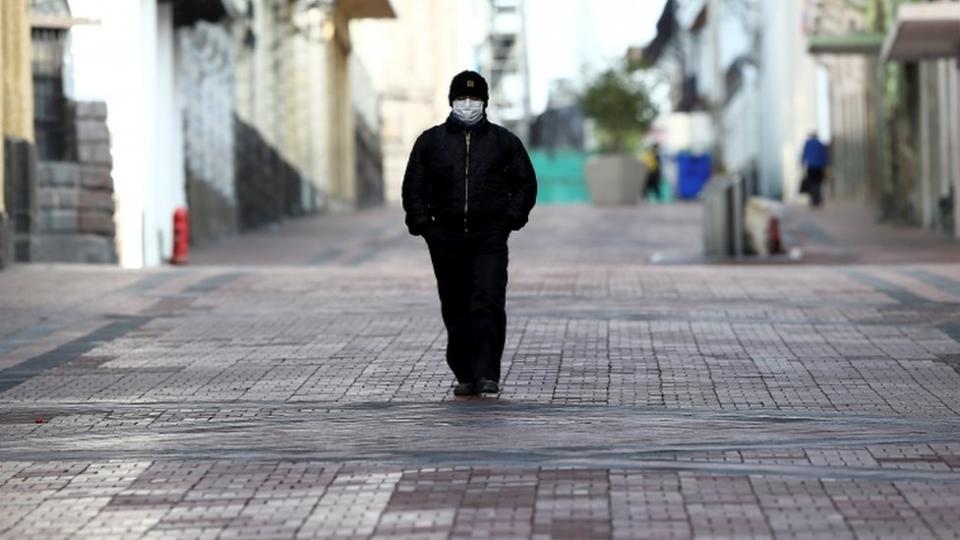 Un hombre camina por el centro de Quito.