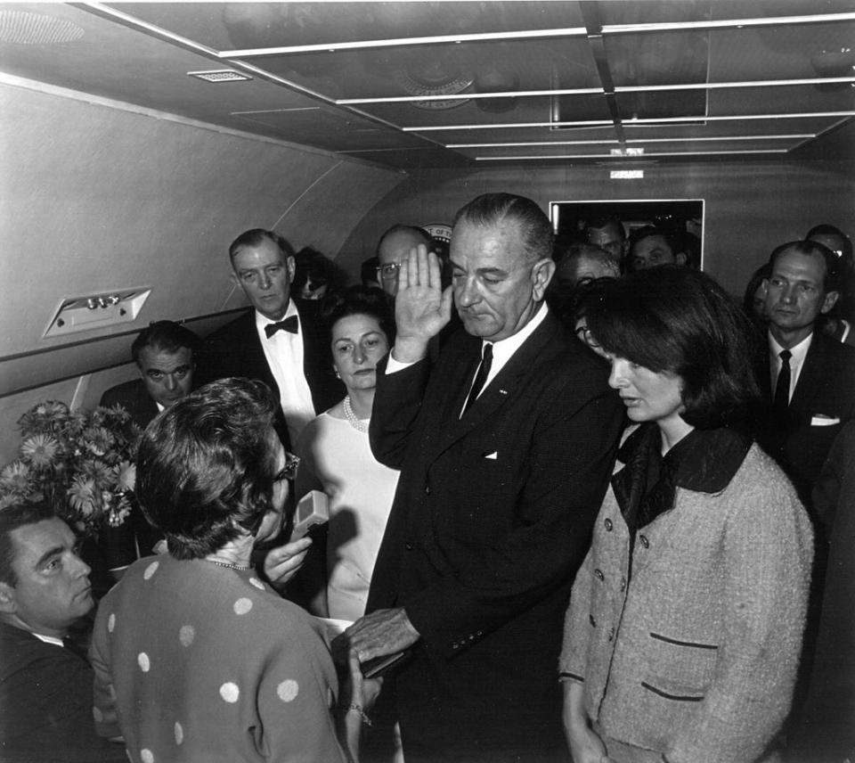 Jacqueline Kennedy (right) watches as US District Judge Sarah Hughes (second from left) administers the oath of office to President Lyndon Johnson (center) (Getty Images)