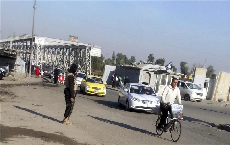 Fotografía facilitada el 14 de noviembre de 2104, de un combatiente del Estado Islamico mientras asegura una calle del centro de Mosul, en el norte de Irak, un día antes. EFE