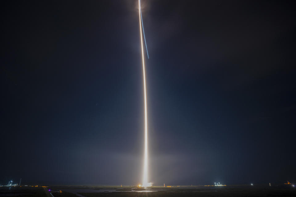 Vulcan Centaur rocket launch streak of light through a dark sky.