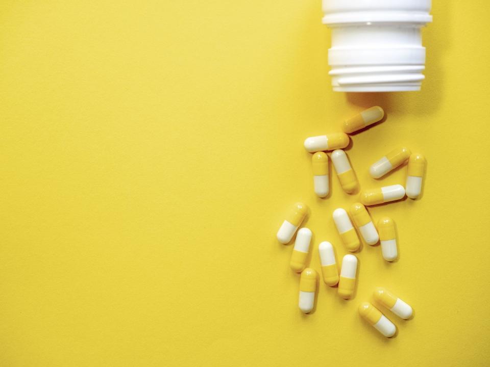 many yellow and white pills on yellow background