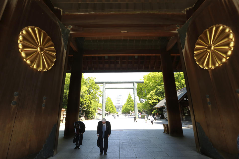 Worshippers bow at the chrysanthemum seal-bedecked gate of Yasukuni Shrine in Tokyo, Wednesday, April 21, 2021, the first day of the annual Spring Rites, the Shinto shrine’s biannual festival honoring the war dead. (AP Photo/Koji Sasahara)