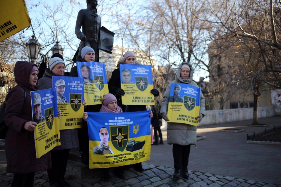 Protesters hold photos of POWs
