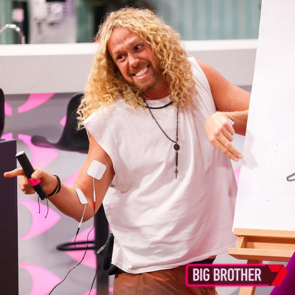 Tim Dormer wears a white top and smiles at the housemates