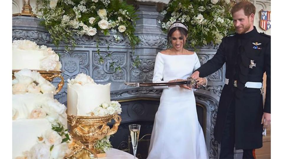 Harry and Meghan cutting wedding cake with ceremonial sword