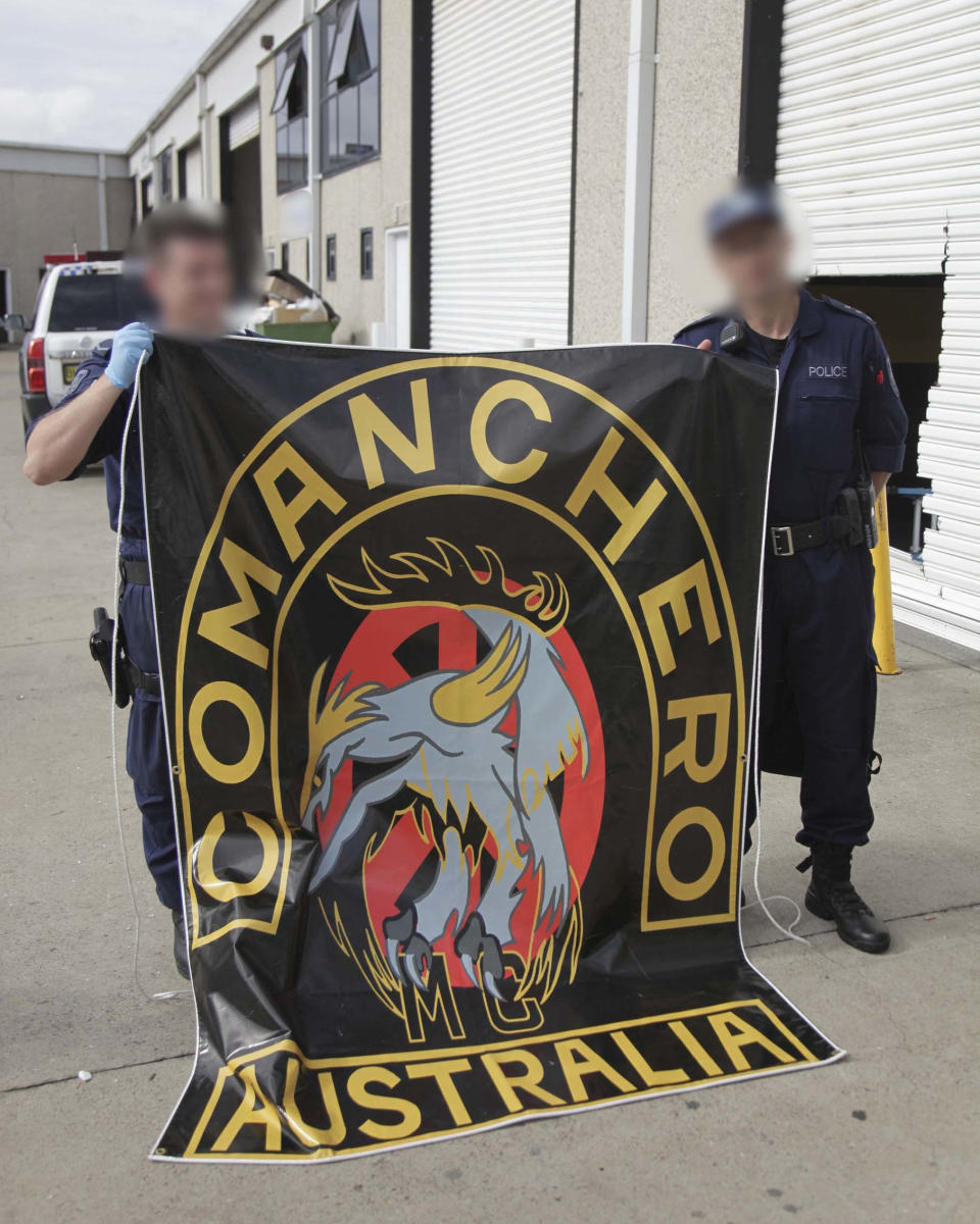 Supplied image of police holding a flag spelling out Comanchero.