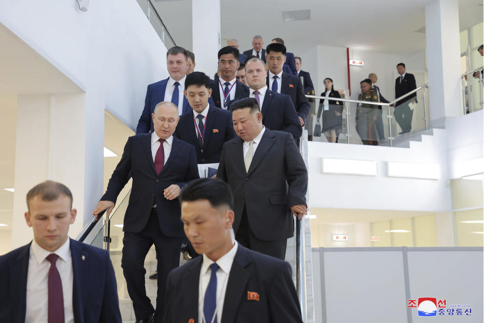 In this photo provided by the North Korean government, Russian President Vladimir Putin, center left, second row, and North Korean leader Kim Jong Un, center, leave a ballroom as they were visiting the Vostochny cosmodrome outside the city of Tsiolkovsky, about 200 kilometers (125 miles) from the city of Blagoveshchensk in the far eastern Amur region, Russia, Wednesday, Sept. 13, 2023. Independent journalists were not given access to cover the event depicted in this image distributed by the North Korean government. The content of this image is as provided and cannot be independently verified. Korean language watermark on image as provided by source reads: "KCNA" which is the abbreviation for Korean Central News Agency. (Korean Central News Agency/Korea News Service via AP)