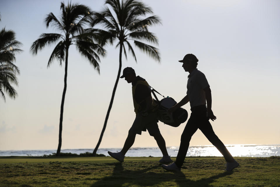 Joaquin Niemann, right, of Chile, walks from the 11th green with caddie Gary Matthews during the second round of the Sony Open golf tournament Friday, Jan. 15, 2021, at Waialae Country Club in Honolulu. (AP Photo/Jamm Aquino)