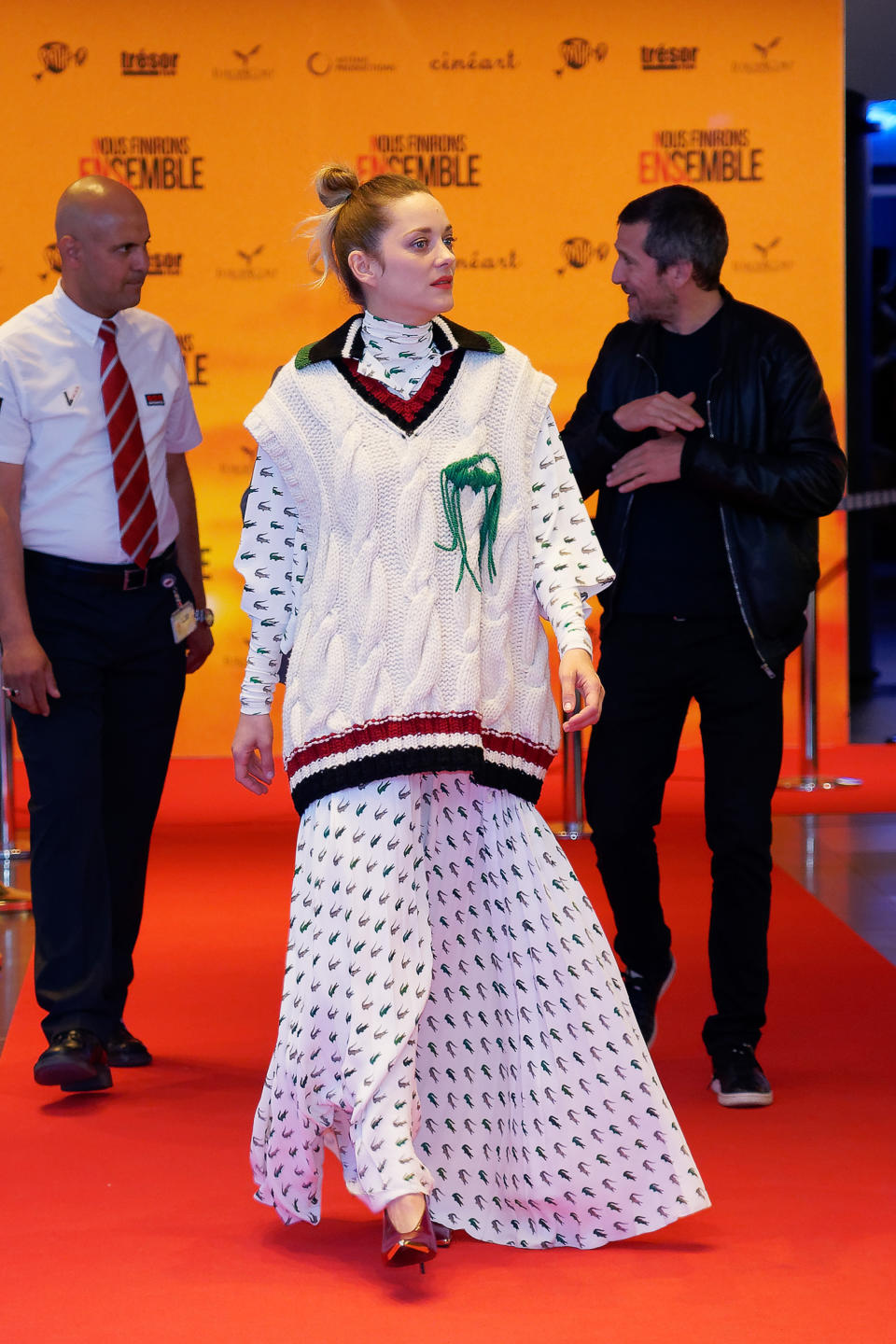 Sehr interessant, wie Marion Cotillard zur Filmpremiere von „Nous finirons Ensemble“ in Brüssel kam. Das Ensemble ihres Outfits stammt von Lacoste und beinhaltet ein Maxikleid mit den klassischen Lacoste-Krokodilen, einen Oversized-Strickpullover ohne Ärmel und Lackpumps, deren Weinrot sich zumindest in einem Streifen des Grobstricks oben wieder fand. Ob das vom Designer tatsächlich so gewollt war und kombiniert werden sollte? (Bild: Getty Images)