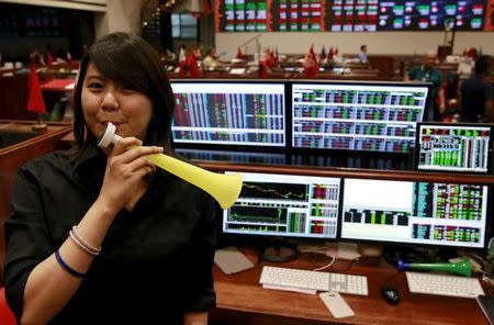 A Filipino trader blows a horn as she poses for the camera inside the Philippine Stock Exchange (PSE) in Makati city, metro Manila December 29, 2015. REUTERS/Romeo Ranoco/Files