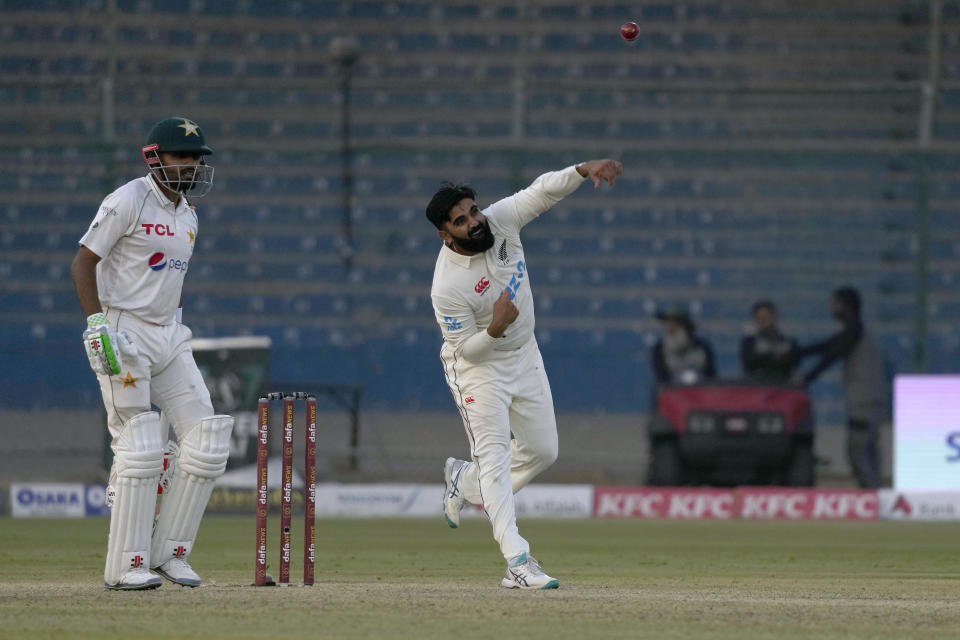 New Zealand's Ajaz Patel, right, bowls as Pakistan's Babar Azam watches during the first day of first test cricket match between Pakistan and New Zealand, in Karachi, Pakistan, Monday, Dec. 26, 2022. (AP Photo/Fareed Khan)