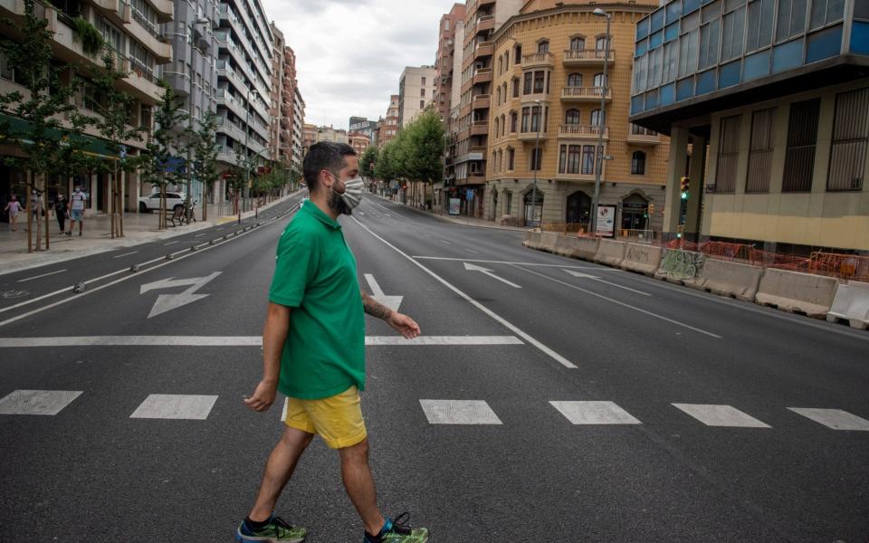 A man with a protective face mask crosses the empty streets of Lleida, Catalonia - RAMON GABRIEL/EPA-EFE/Shutterstock/Shutterstock