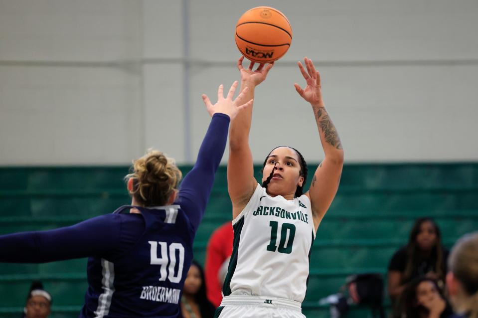 Edyn Battle of Jacksonville University launches a shot on Saturday at Swisher Gym over UNF's Emma Broermann. Battle led the Dolphins with 22 points in a 73-60 victory.