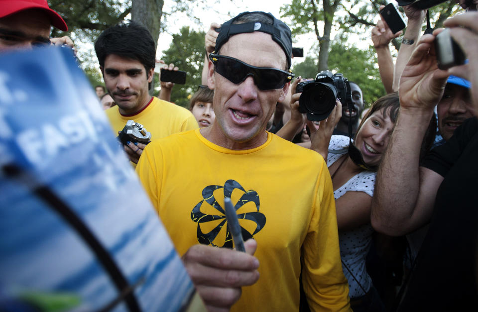 Lance Armstrong signs autographs for supporters after a run, Wednesday, Aug. 29, 2012, on Mont Royal Park in Montreal. 