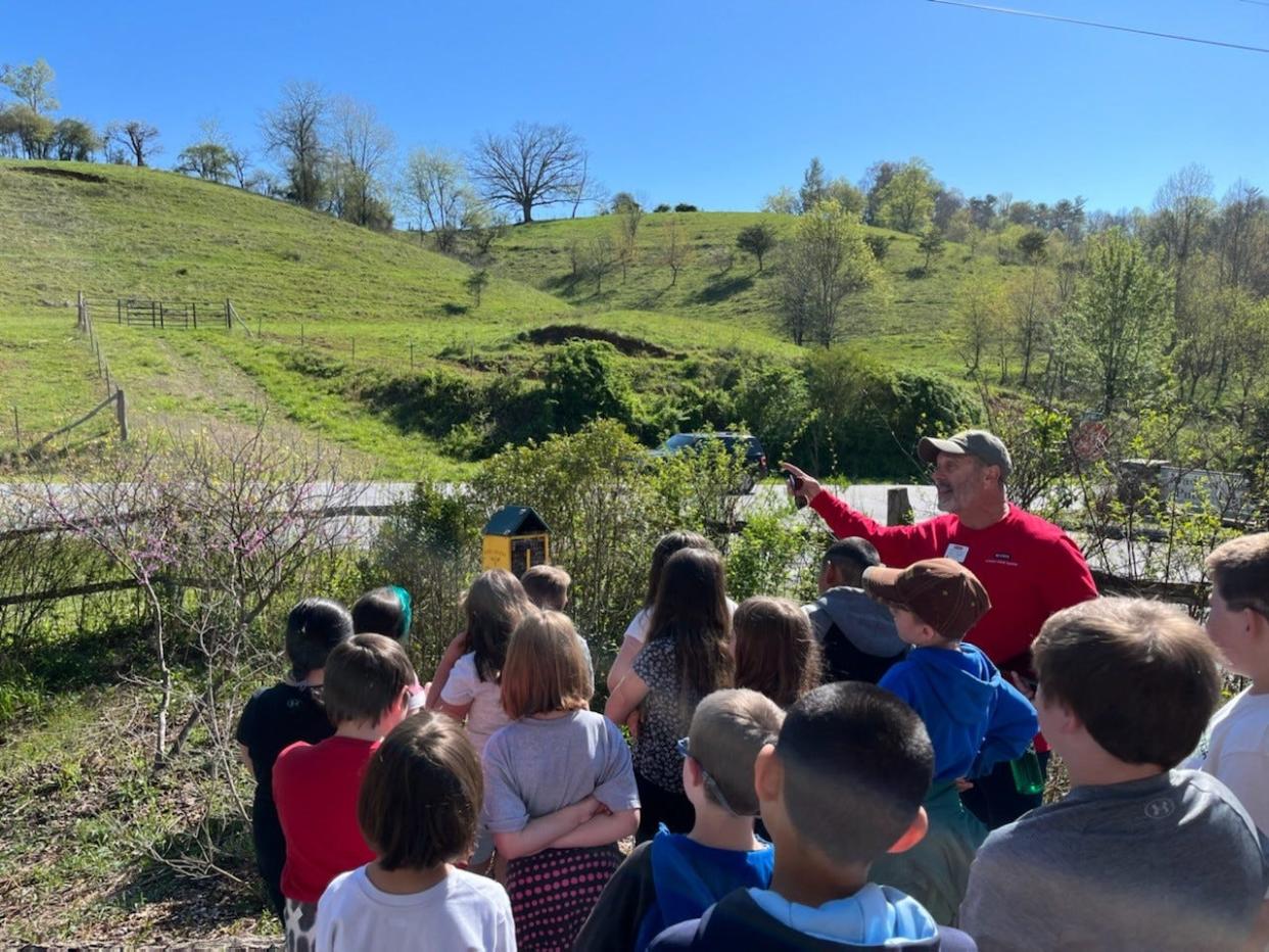 Madison County Garden Club's Scoot Moore, pictured in red, led Hot Springs Elementary School third graders on a tour of Marshall Native Garden's 11 themed gardens April 11.