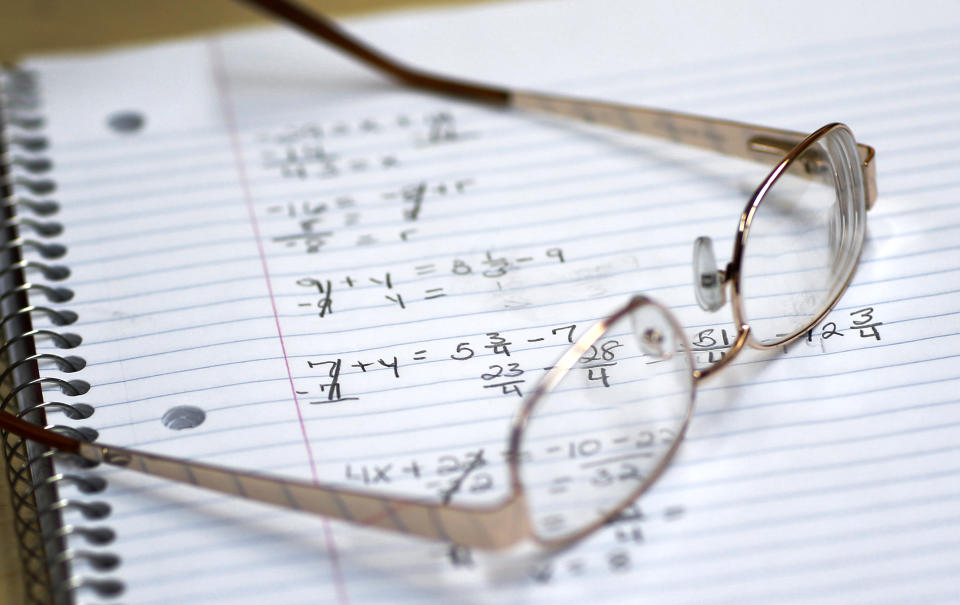 This photo taken March 12, 2014, shows a student's glasses sitting on a notebook containing math exercises in a remedial mathematics course at Baltimore City Community College in Baltimore. Only about a quarter of students nationally who take developmental _ or remedial _ classes ever graduate. The problem is so profound that the advocacy group Complete College America dubs remedial classes the “bridge to nowhere.” The challenge, educators say, is that even as billions is spent annually on remedial classes, many of these students run out of financial aid before they can complete their credit requirements, get discouraged by non-credit classes or find themselves unable to complete them. The Baltimore school is one of several places around the country looking to improve the odds for these students. (AP Photo/Patrick Semansky)