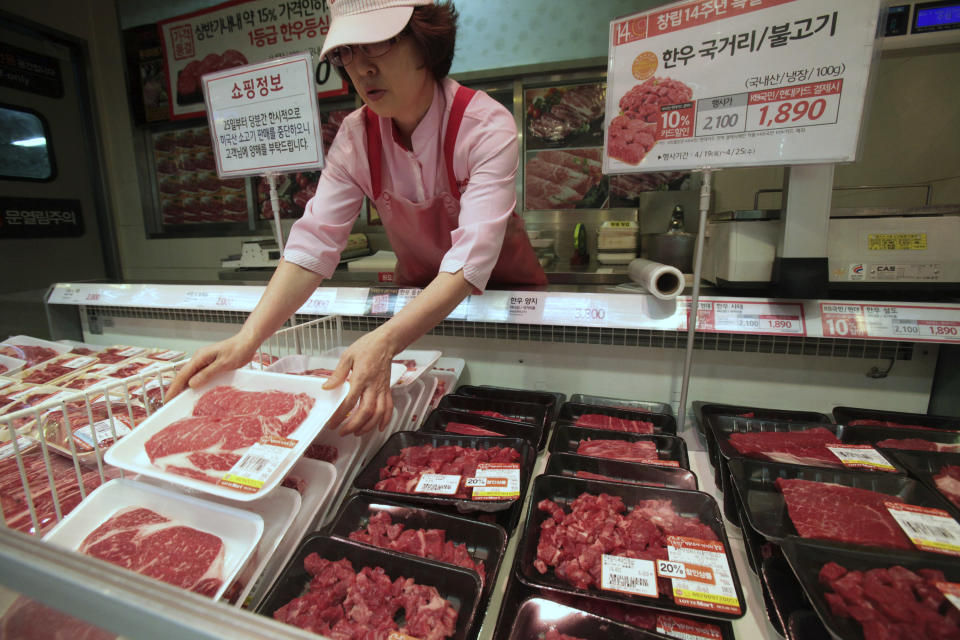 A South Korean store employee sets out packs of domestic beef on the shelves at a Lotte Mart store in Seoul, South Korea, Wednesday, April 25, 2012. Two major South Korean retailers, including Lotte Mart, suspended sales of U.S. beef Wednesday following the discovery of mad cow disease in a U.S. dairy cow. Reaction elsewhere in Asia was muted with Japan saying there's no reason to restrict imports. The letters on a card at left top read " Starting from the 25th, we will temporarily stop the sales of the US beef. Thank you for your understanding". (AP Photo/Ahn Young-joon)