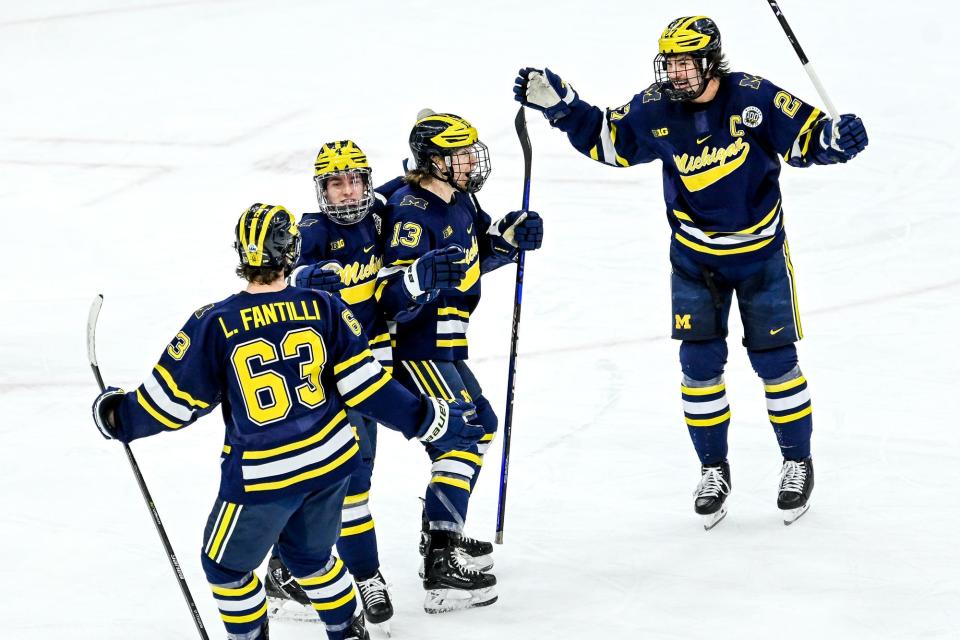 Michigan's T.J. Hughes, center, celebrates his goal with teammates during the first period in the game against Michigan State on Friday, Dec. 9, 2022, at Munn Arena in East Lansing.