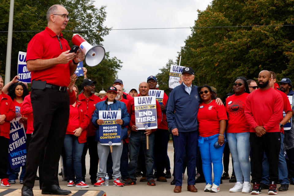 Shawn Fain, president of the United Auto Workers, with President Biden and striking autoworkers at the GM Willow Run Distribution Center in Belleville, Mich.