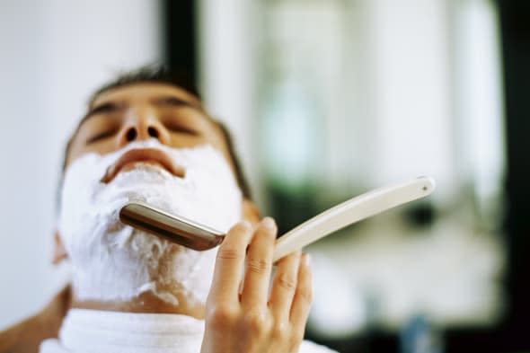 barber shaving a young man