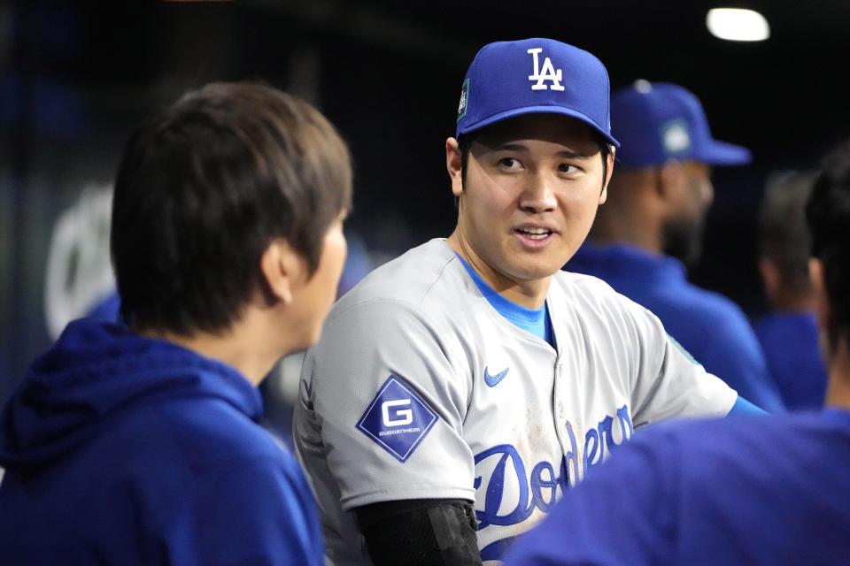 Los Angeles Dodgers designated hitter Shohei Ohtani, right, talks with interpreter Ippei Mizuhara during the ninth inning of an opening day baseball game against the San Diego Padres at the Gocheok Sky Dome in Seoul, South Korea Wednesday, March 20, 2024, in Seoul, South Korea. (AP Photo/Lee Jin-man)