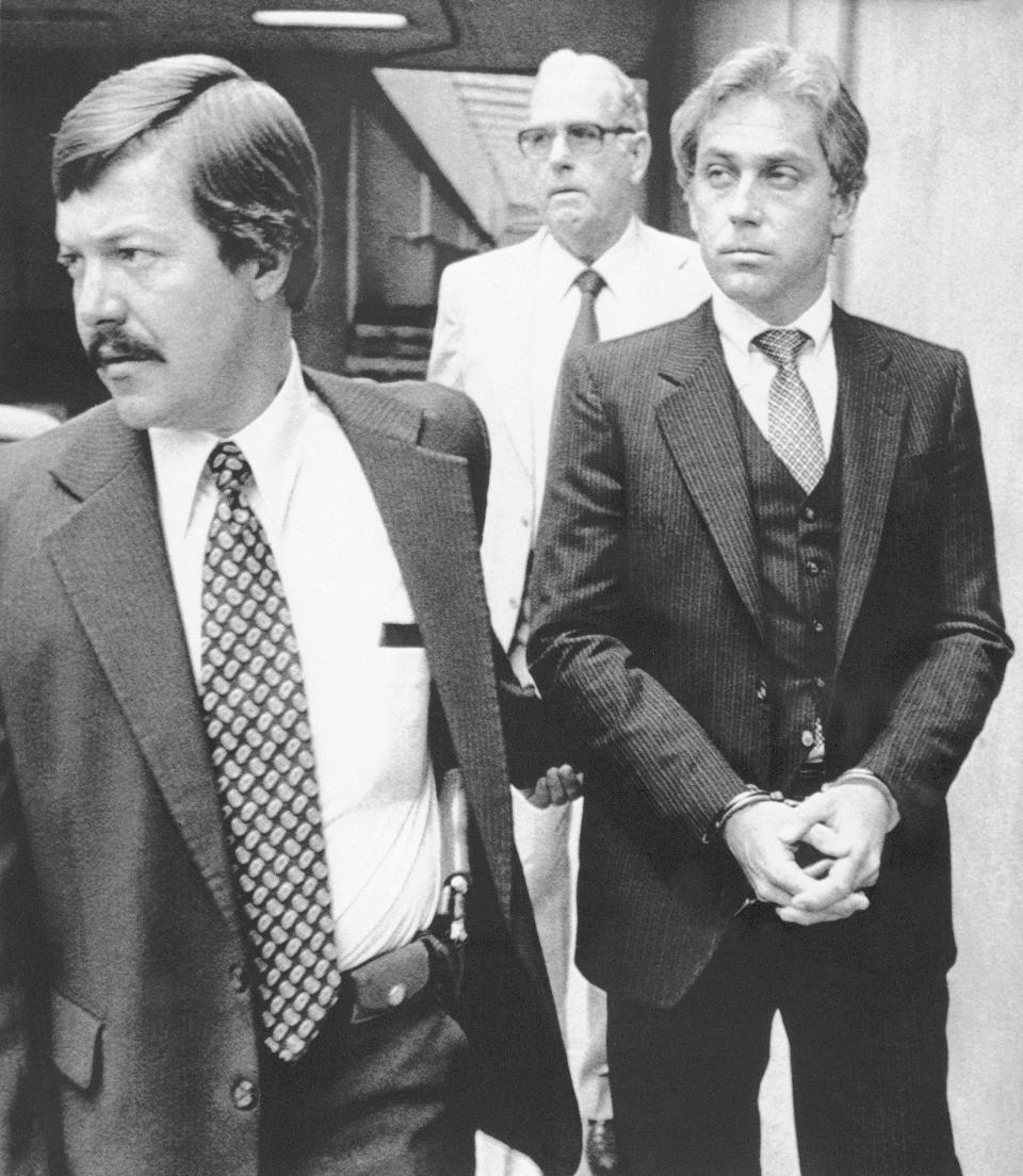 FILE - In this Aug. 28, 1979, file photo, a handcuffed Dr. Jeffrey MacDonald is led away from Federal Court in Raleigh, N.C., after a jury found him guilty of one count of first degree murder and the two counts of second degree murder. The former Army doctor convicted for the 1970 slayings of his wife and two young daughters at North Carolina's Fort Bragg has ended his appeal of a court ruling denying his requested release. The 4th U.S. Circuit Court of Appeals granted MacDonald's appeal dismissal on Thursday, Sept. 16, 2021. (AP Photo, File)