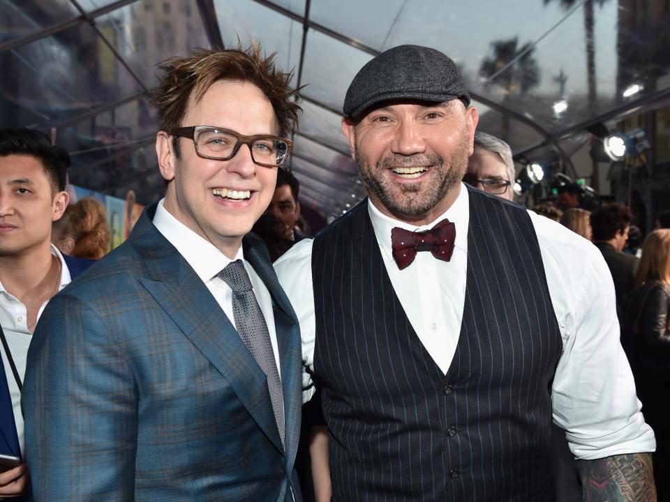 James Gunn in a suit next to Dave Bautista in a vest, white shirt