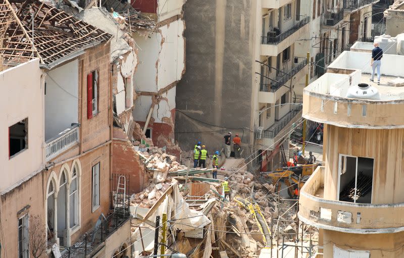 Voluntarios y un miembro del equipo de rescate chileno excavan entre los escombros de edificios que colapsaron debido a la explosión en el área del puerto, luego de que se detectaran señales de vida, en Gemmayze, Beirut, Líbano