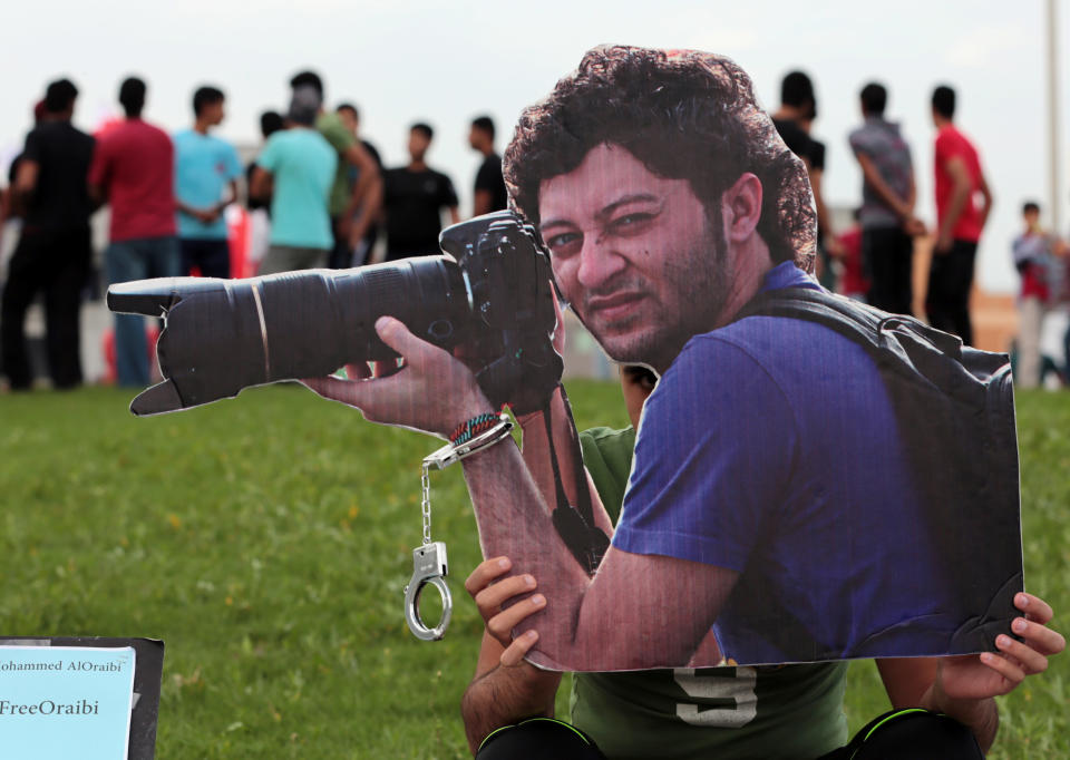 A Bahraini photographer holds up a cutout picture of jailed photographer Ahmed Humaidan in 2014. (Hasan Jamali/AP)