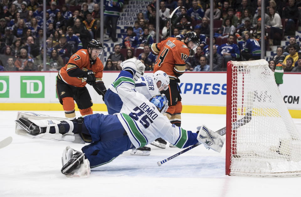 Vancouver Canucks goalie Thatcher Demko (35) dives across the crease as Troy Stecher (51) stops Anaheim Ducks' Nick Ritchie (37) while Adam Henrique (14) watches during the third period of an NHL hockey game Sunday, Feb. 16, 2020, in Vancouver, British Columbia. (Darryl Dyck/The Canadian Press via AP)