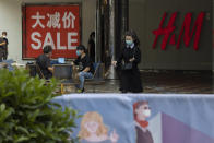 Shoppers wearing mask to curb the spread of the coronavirus visit a retail district in Beijing on July 22, 2020. China's factory output rose just under 5% last month from a year earlier while retail sales fell slightly, suggesting the country's recovery from the coronavirus pandemic remains muted. (AP Photo/Ng Han Guan)