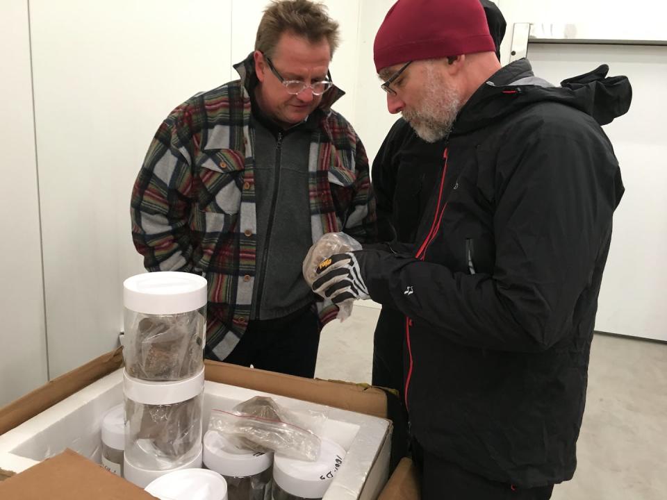 Geomorphologist Paul Bierman (right) and geochemist Joerg Schaefer of Columbia University examine the jars holding Camp Century sediment for the first time. They were in a Danish freezer set at -17 F. Paul Bierman, <a href="http://creativecommons.org/licenses/by-nd/4.0/" rel="nofollow noopener" target="_blank" data-ylk="slk:CC BY-ND;elm:context_link;itc:0;sec:content-canvas" class="link ">CC BY-ND</a>