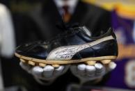 Kendall Capps holds a pair of soccer boots worn and autographed by late soccer star Diego Armando Maradona ahead of the upcoming "Sports: Legends" auction in Culver City