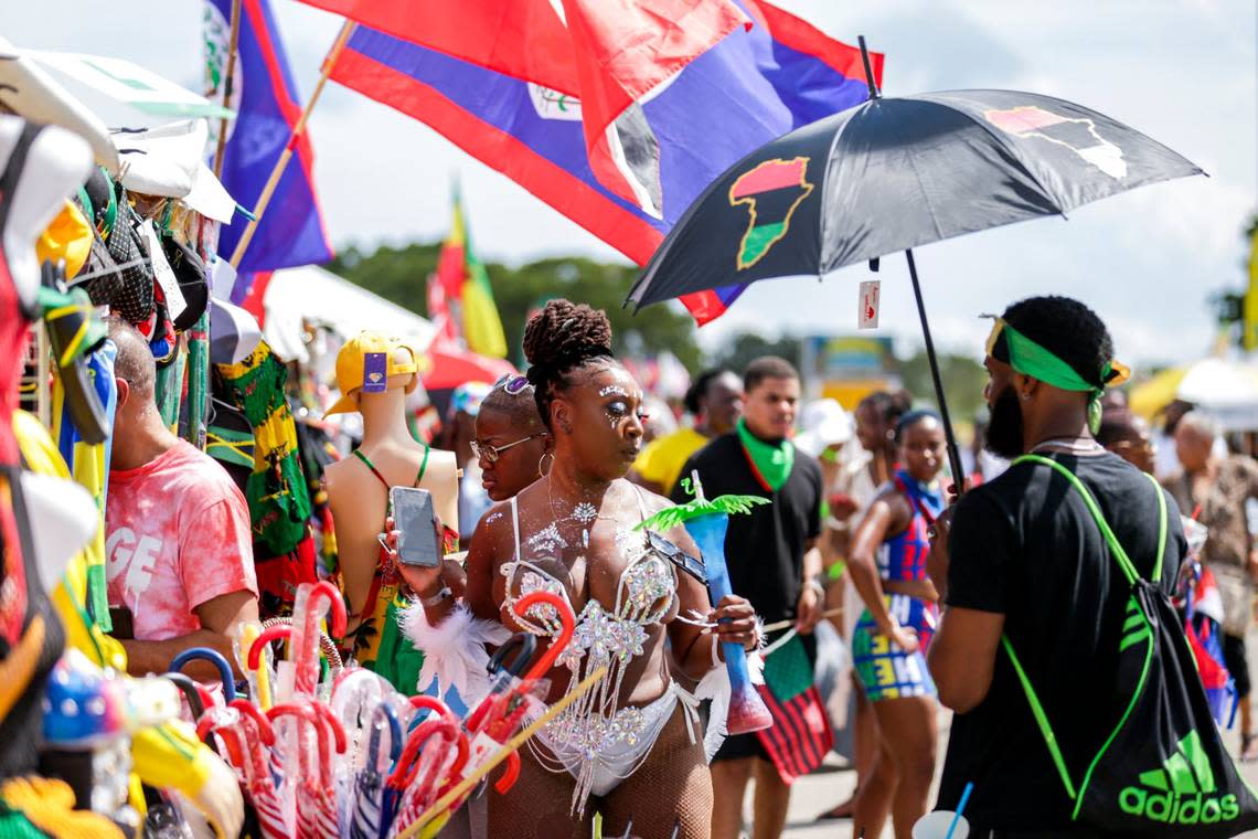Costumed revelers shop for souvenirs at the 2021 Miami Carnival at the Miami-Dade County Fairgrounds.