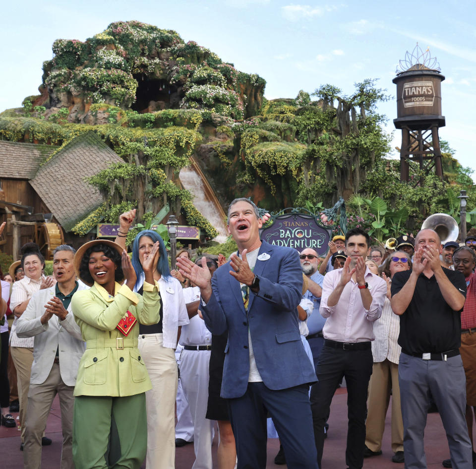 With Princess Tiana, Walt Disney World president Jeff Vahle cheers employees during a "Thank You Fête" honoring cast members at a preview event for Tiana's Bayou Adventure at the Magic Kingdom in Bay Lake, Fla., Monday, June 10, 2024. The ride —redeveloped from the park's original Splash Mountain— officially opens to Disney guests on June 28. (Joe Burbank/Orlando Sentinel via AP)