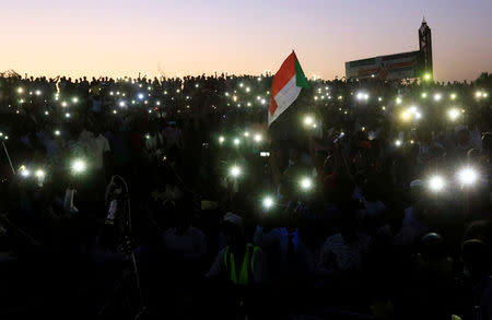 Sudanese demonstrators use their mobile phones torches as electric lamps as they attend a mass anti-government protest outside Defence Ministry in Khartoum, Sudan April 21, 2019. REUTERS/Mohamed Nureldin Abdallah